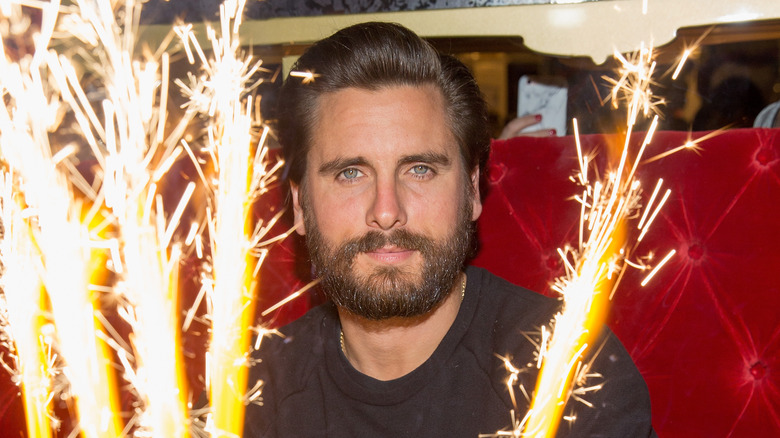 Scott Disick in front of sparklers