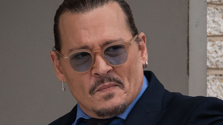Johnny Depp with sunglasses on, smirking