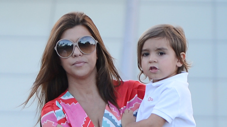 Kourtney Kardashian carrying Mason Disick