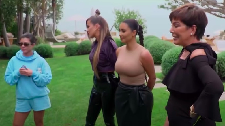 Kourtney, Khloe, Kim, and Kris looking emotional as they talk on the lawn