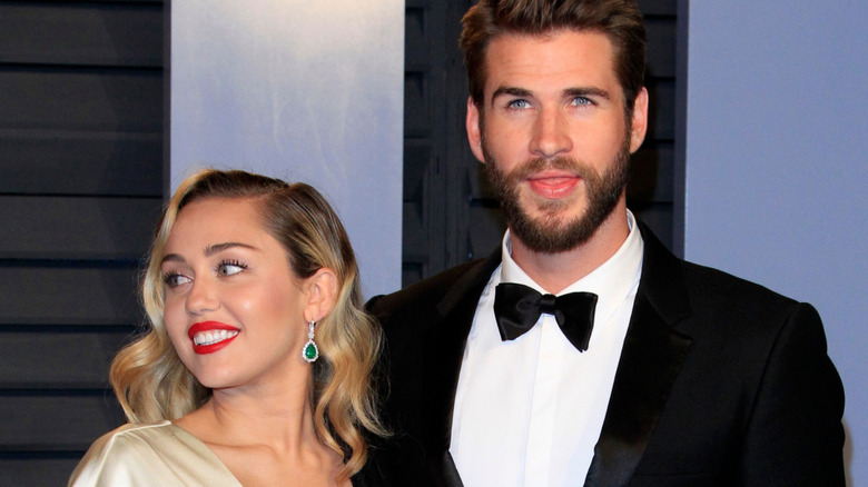 Miley Cyrus and Liam Hemsworth standing together