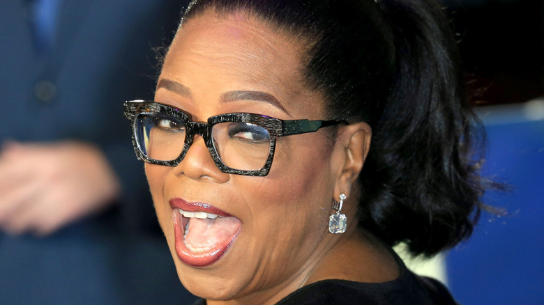 Oprah Winfrey smiling big over shoulder