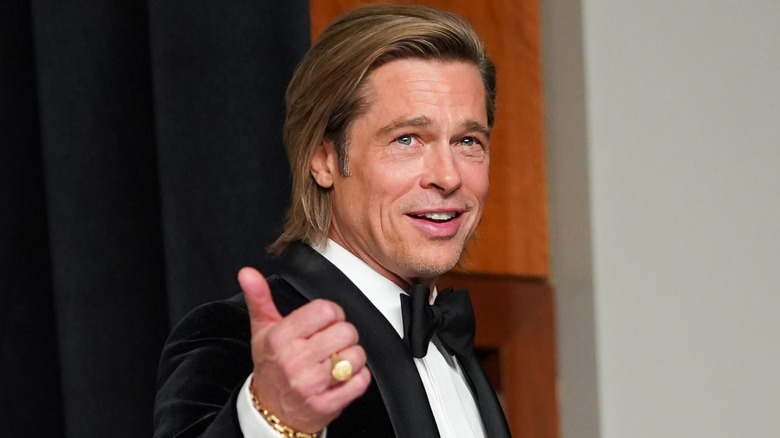 Brad Pitt flashing a thumbs up at the 2020 Oscars.