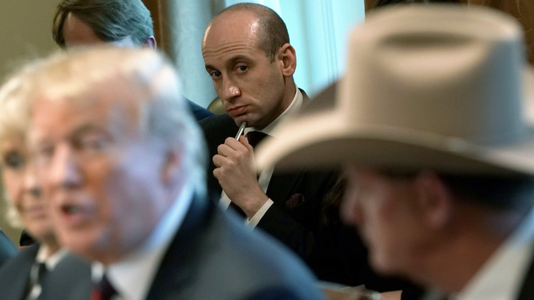 Stephen Miller looks on as Donald Trump speaks in a meeting.