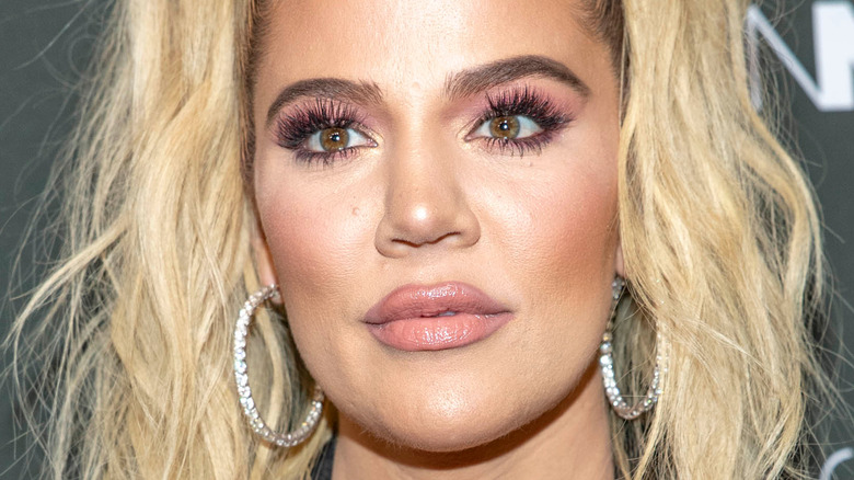 Khloe Kardashian poses with hoop earrings.