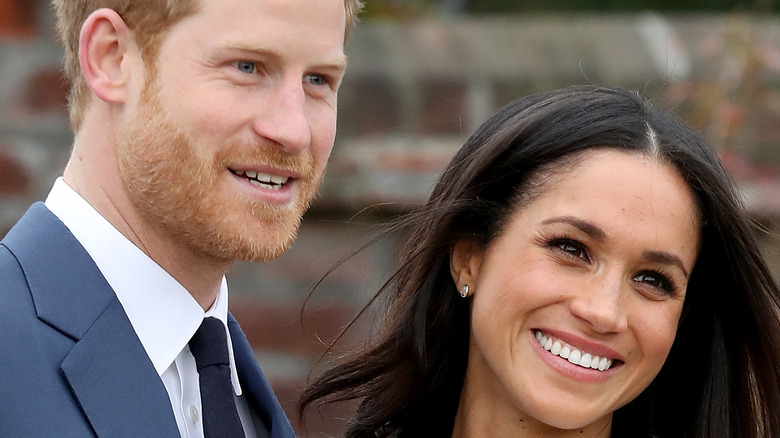 Prince Harry and Meghan Markle smile in formal attire