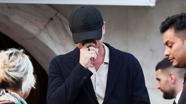 Leonardo DiCaprio hides his face with a black baseball cap at Jeff Bezos' wedding