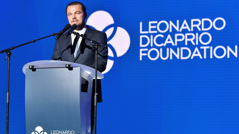 Leonardo DiCaprio speaking at a podium at his environmental foundation