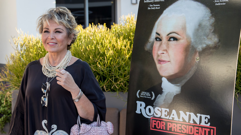 Roseanne Barr standing next to a poster of her documentary Roseanne for President!