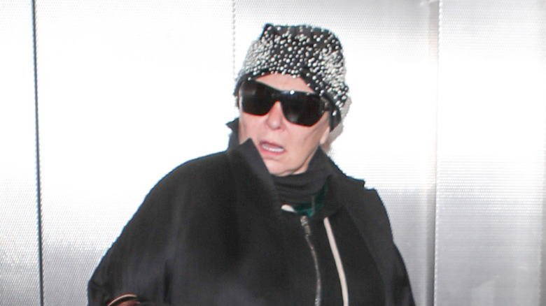 Roseanne Barr in sunglasses and black coat in an elevator at LAX