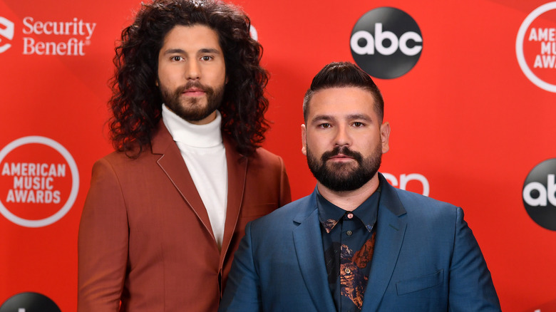 Dan + Shay posing against red backdrop