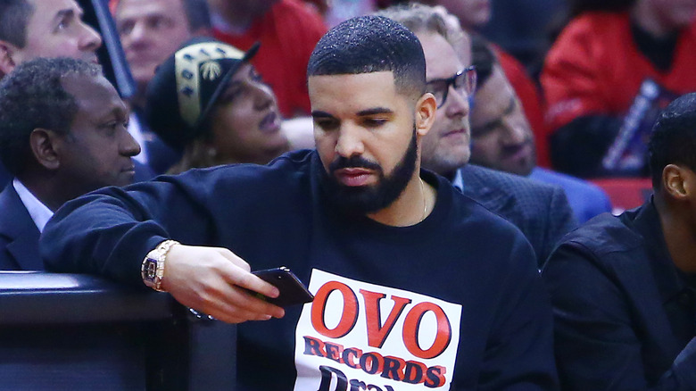 Drake looking at his phone