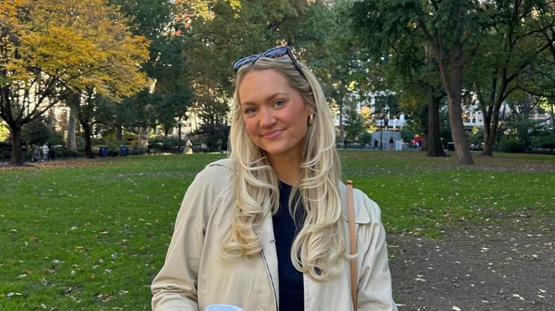 Dressed in a beige jacket Paige Drummond tilts her head to the side and smiles gently.