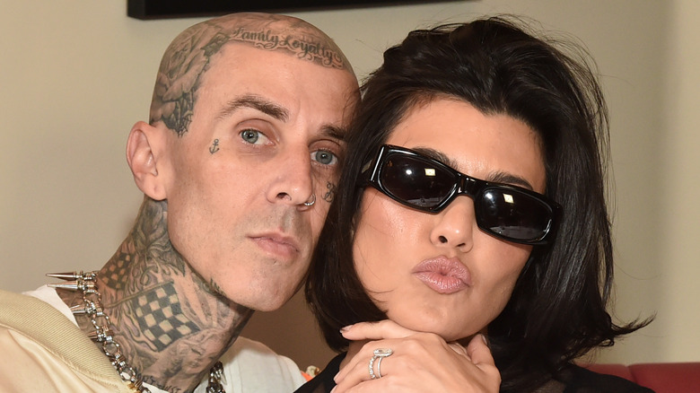 Travis Barker posing with Kourtney Kardashian