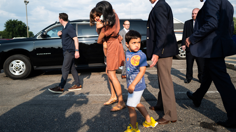 Usha Vance carrying her daughter into a meet-and-greet.