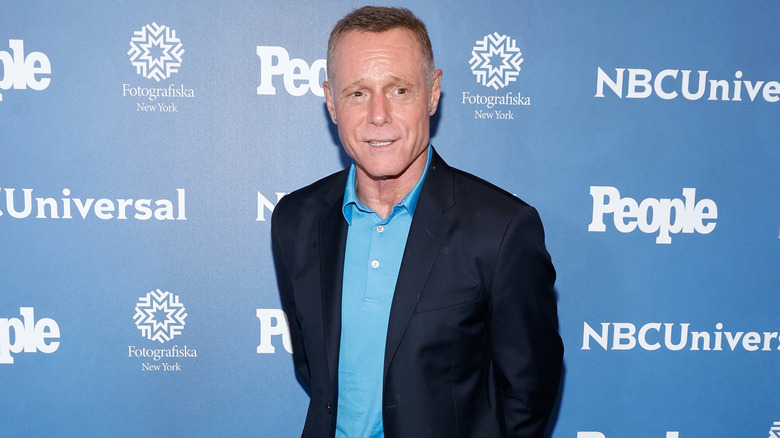 Jason Beghe posing in a blue polo shirt and dark blazer