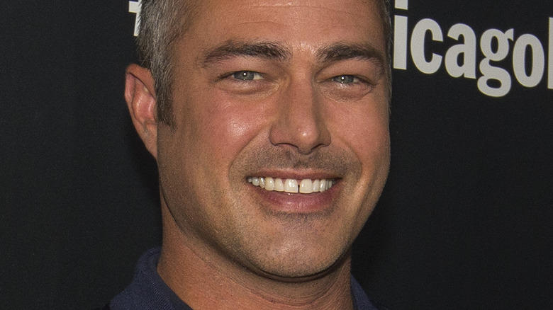 Taylor Kinney smiling on step and repeat