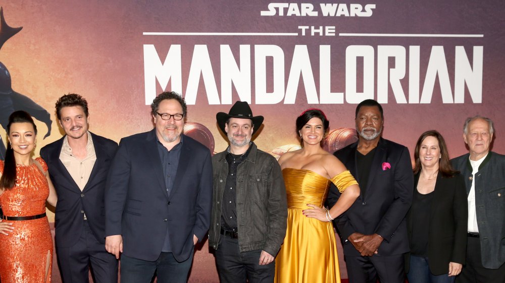 The Mandalorian cast in front of promo poster