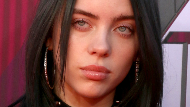 Billie Eilish with serious expression on red carpet