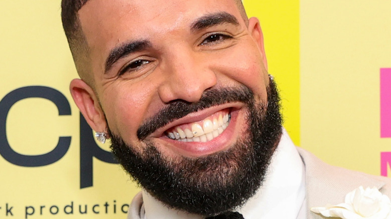 Drake with wide smile on the red carpet