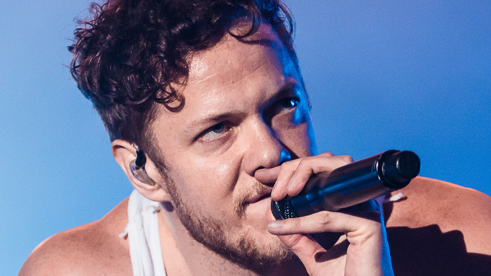 Dan Reynolds Imagine Dragons crouched singing