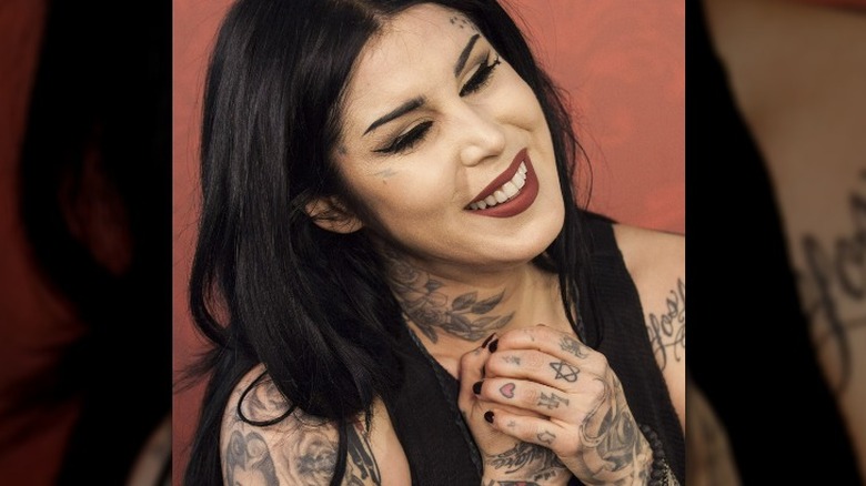 Kat Von D laughing showing off hand tattoos