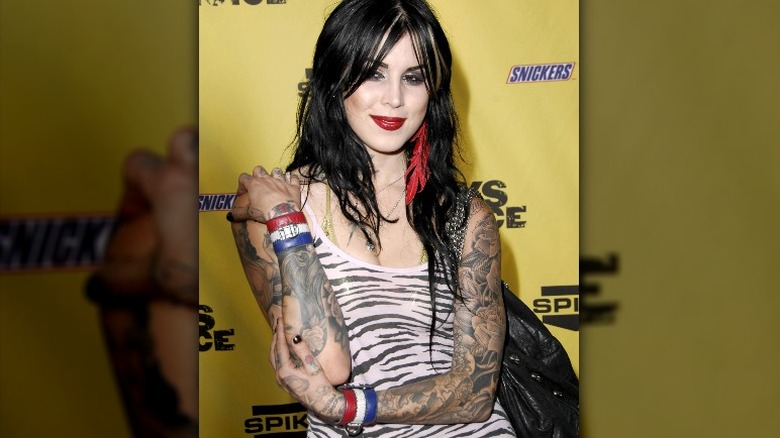 Kat Von D posing in zebra tank and wrist cuffs