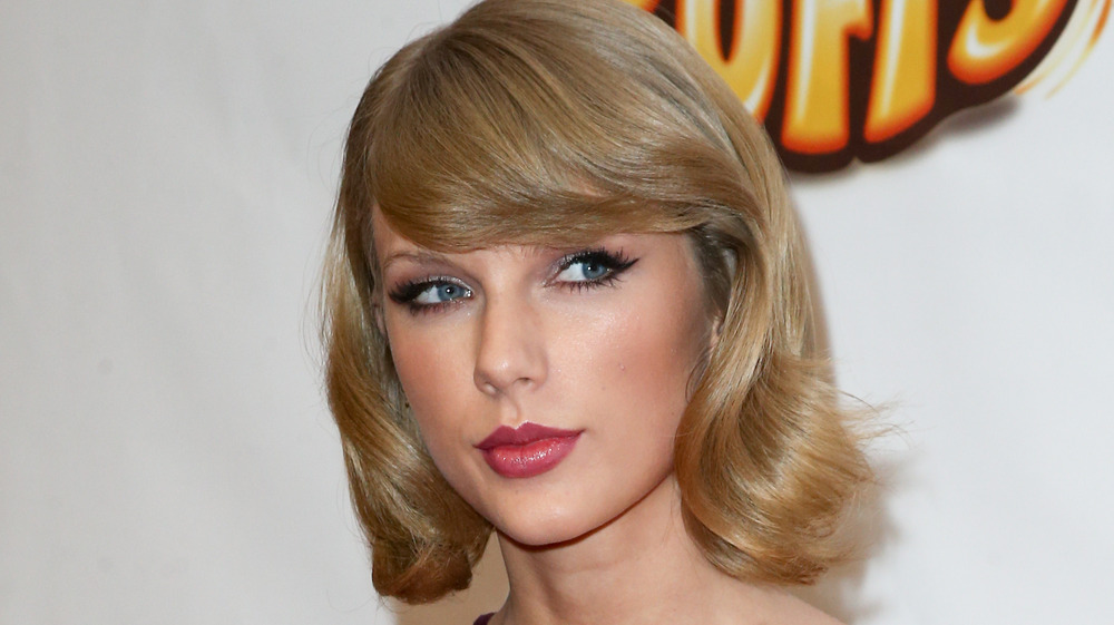 Taylor Swift purses her lips while posing on the red carpet