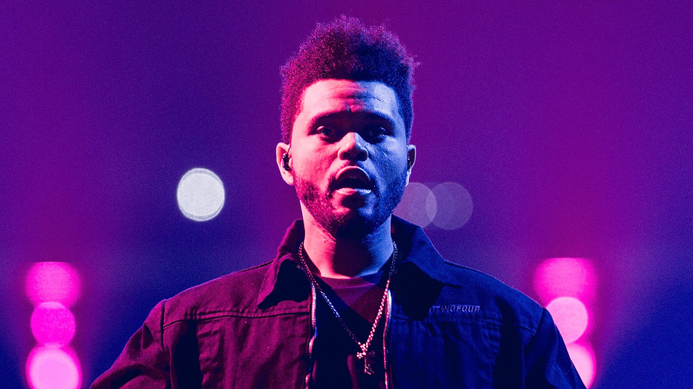 The Weeknd performing in purple lighting