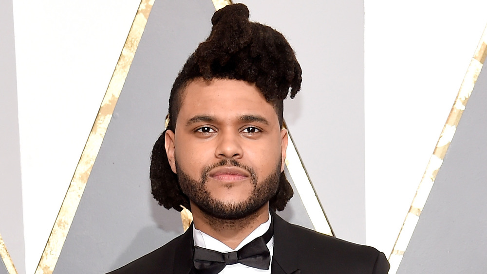 The Weeknd smirking on the red carpet