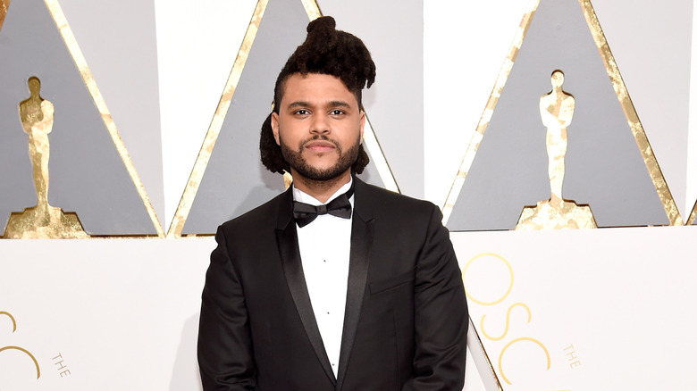 The Weeknd smirking on the red carpet
