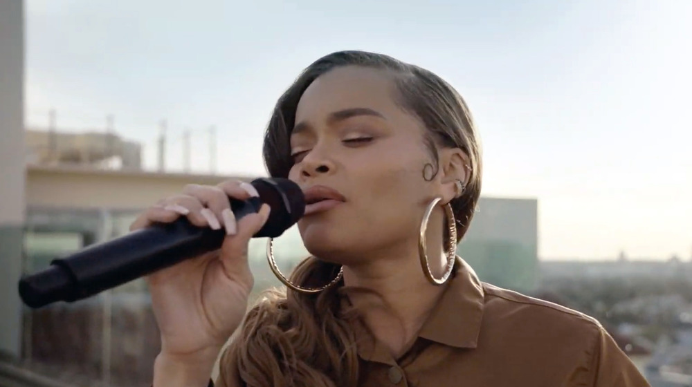  Andra Day singing in a microphone