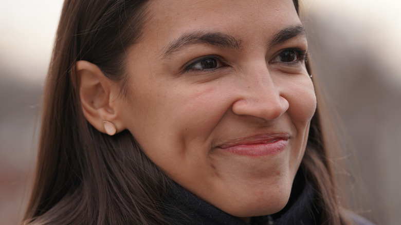AOC smiles with lips closed