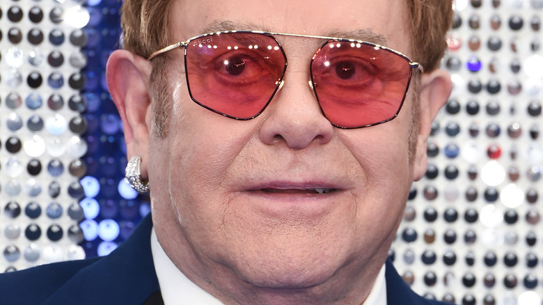Elton John wearing wire-frame glasses