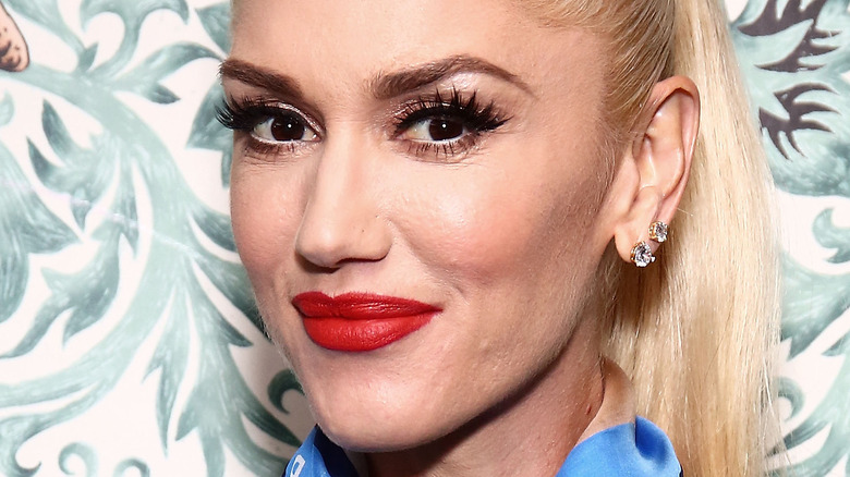Gwen Stefani smiles in red lipstick.
