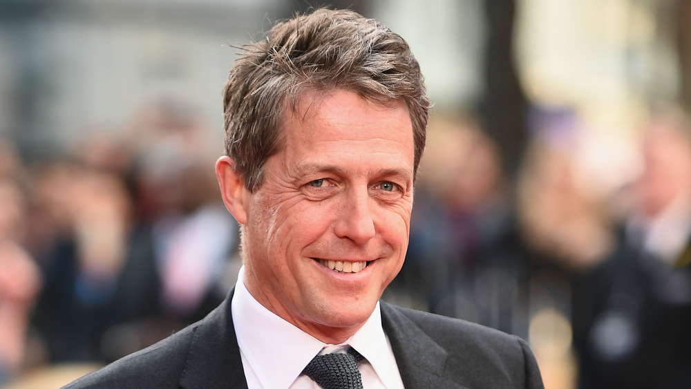 Hugh Grant smiling on the red carpet