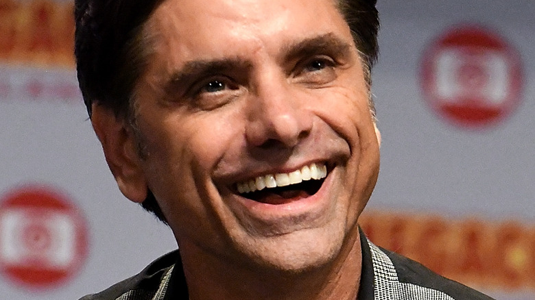 John Stamos with wide smile looking up
