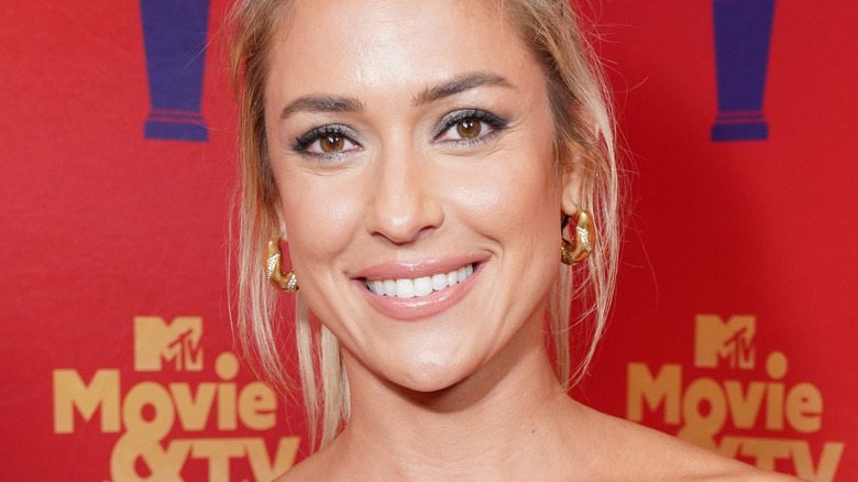 Kristin Cavallari smiling on a red carpet, wearing hoop earrings