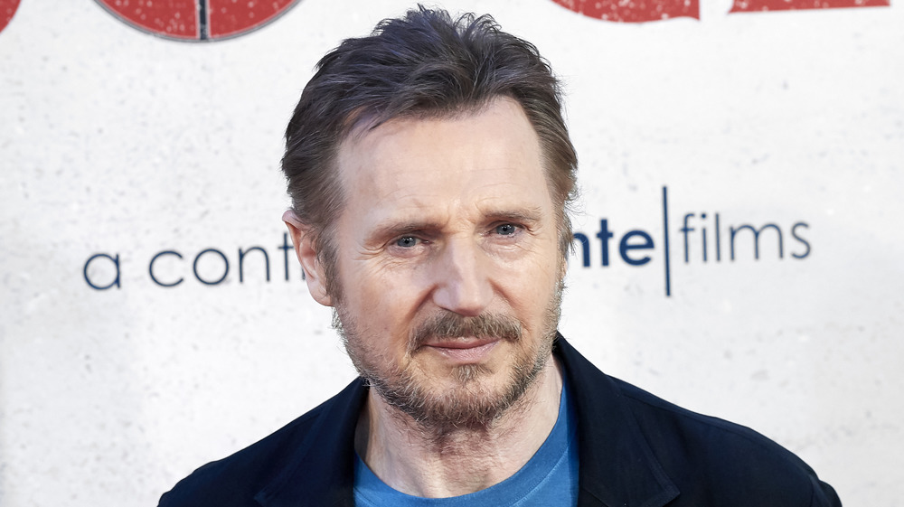 Liam Neeson with a beard posing on the red carpet