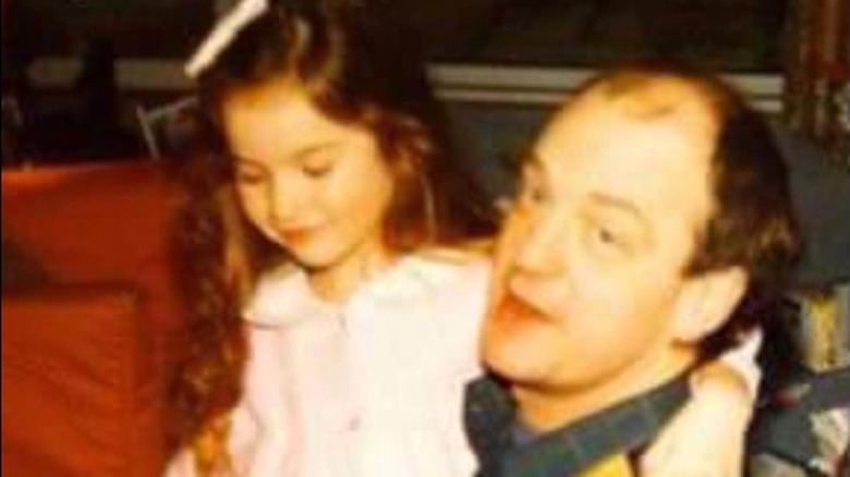 Lily James as a child with arm draped around her father