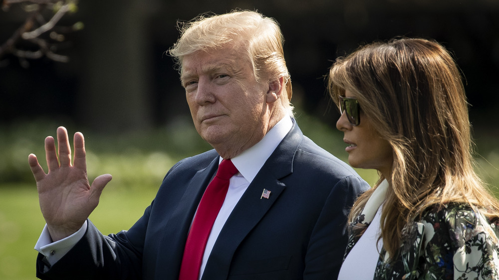 Donald Trump waving to a crowd with Melania Trump