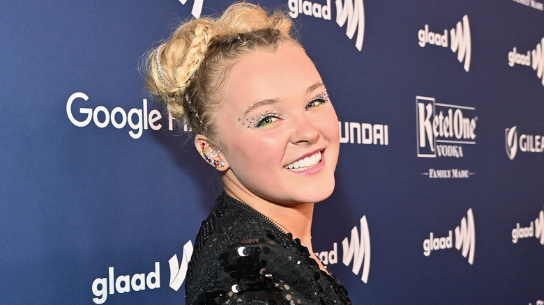 JoJo Siwa smiling over her shoulder