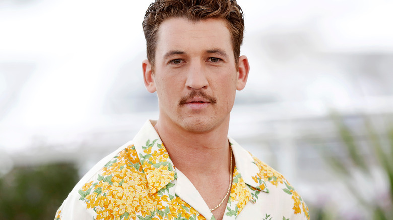 Miles Teller stares intensely at a photo call