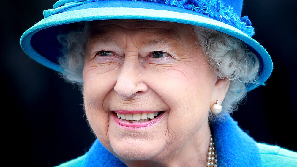 Queen Elizabeth II wears a blue hat 