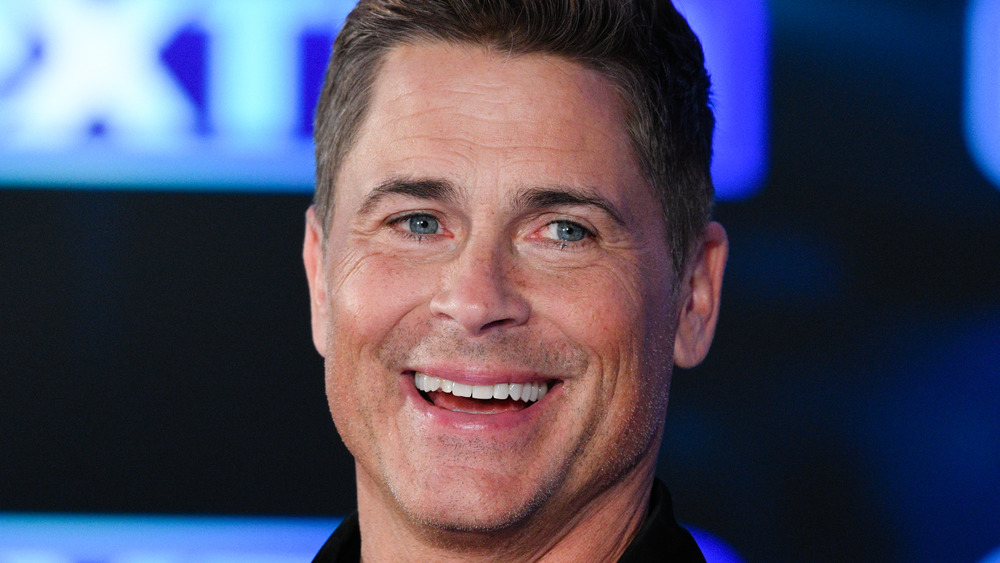 Rob Lowe smiles at the camera during an interview