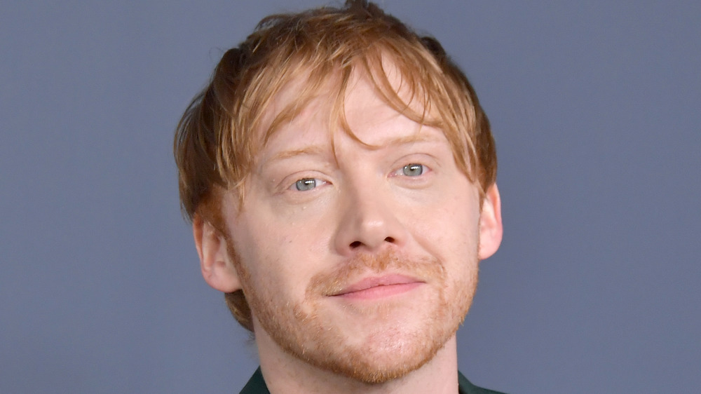 Rupert Grint smiles at an event