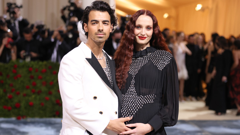 Joe Jonas with hand on Sophie Turner's baby bump
