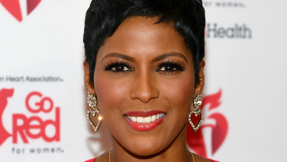 Tamron Hall smiling at a red carpet event