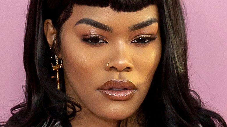 Teyana Taylor poses with cross earring and nose piercing.