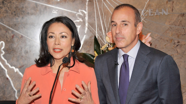 Ann Curry speaking at a podium with a microphone with Matt Lauer standing next to her